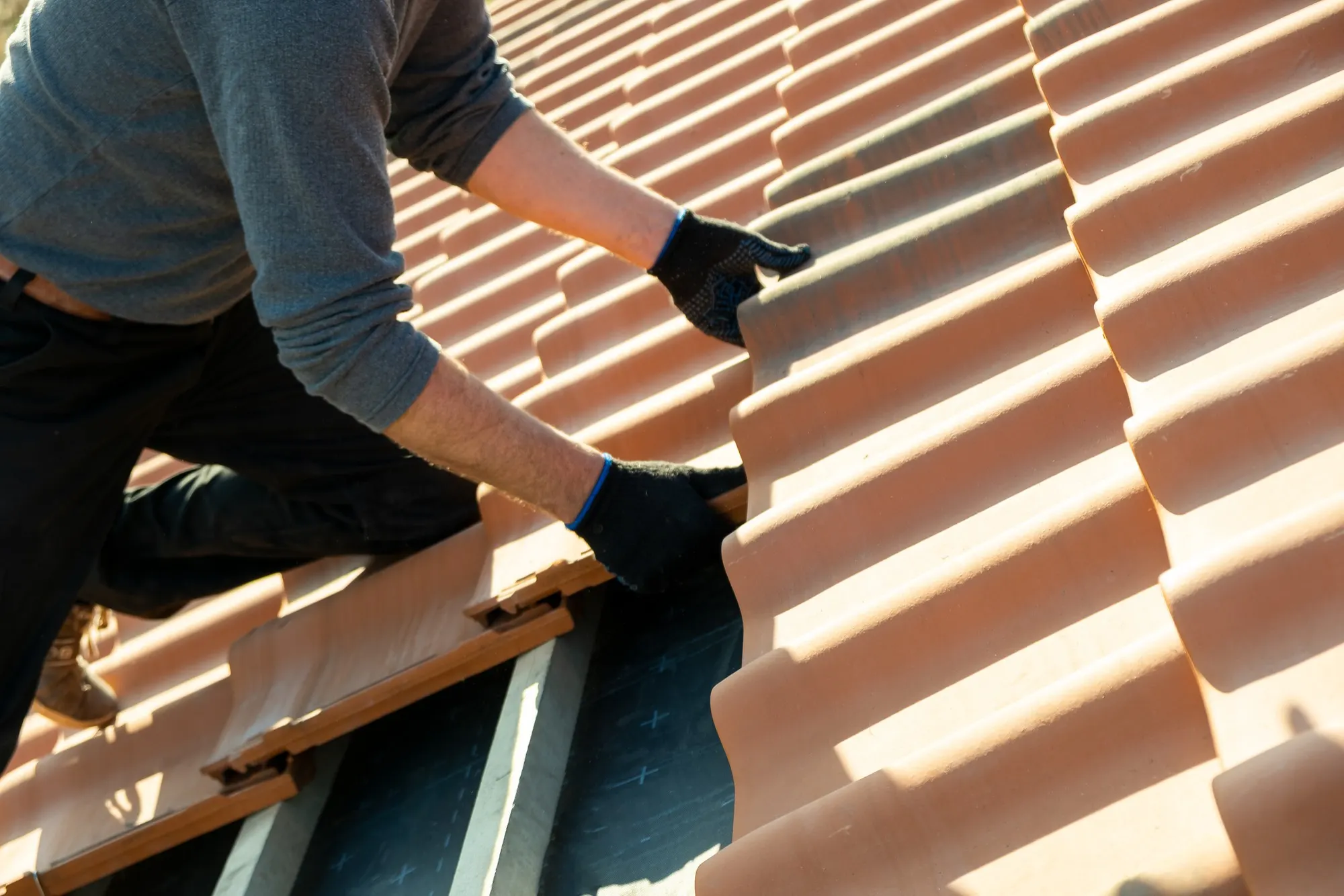 Tradesperson installing tile roofing